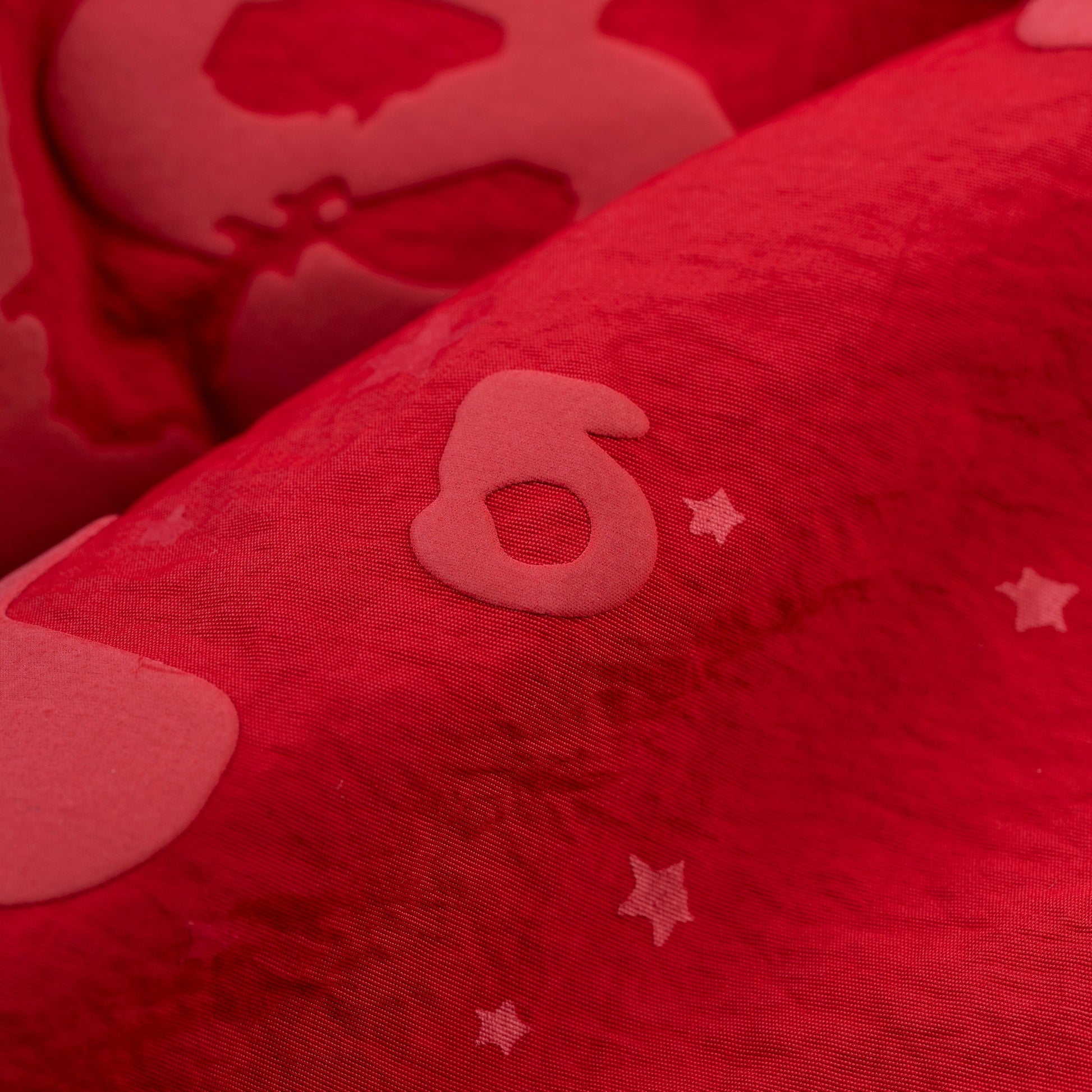 Detail view of Beluga puff print on SP5DER short in Red