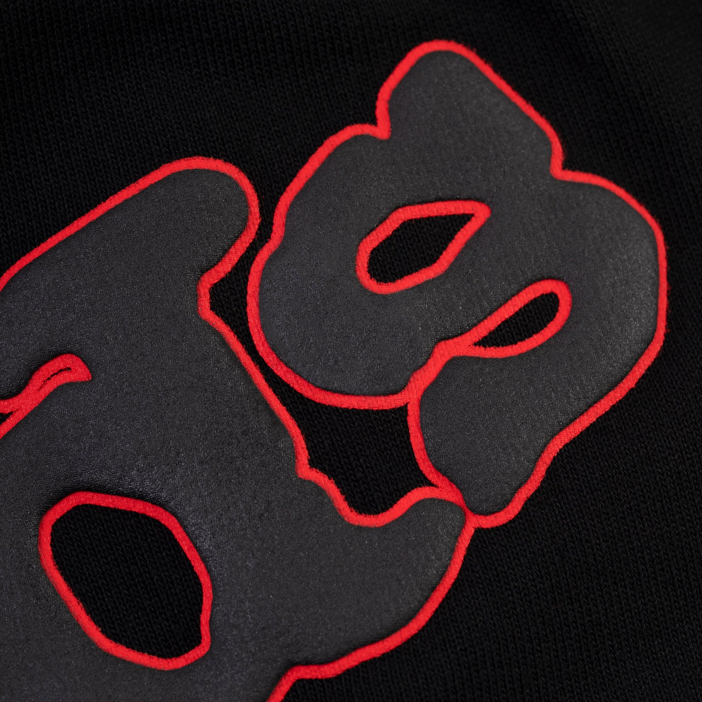 Detail view of contrast print outlining on SP5DER sweatshort in Black