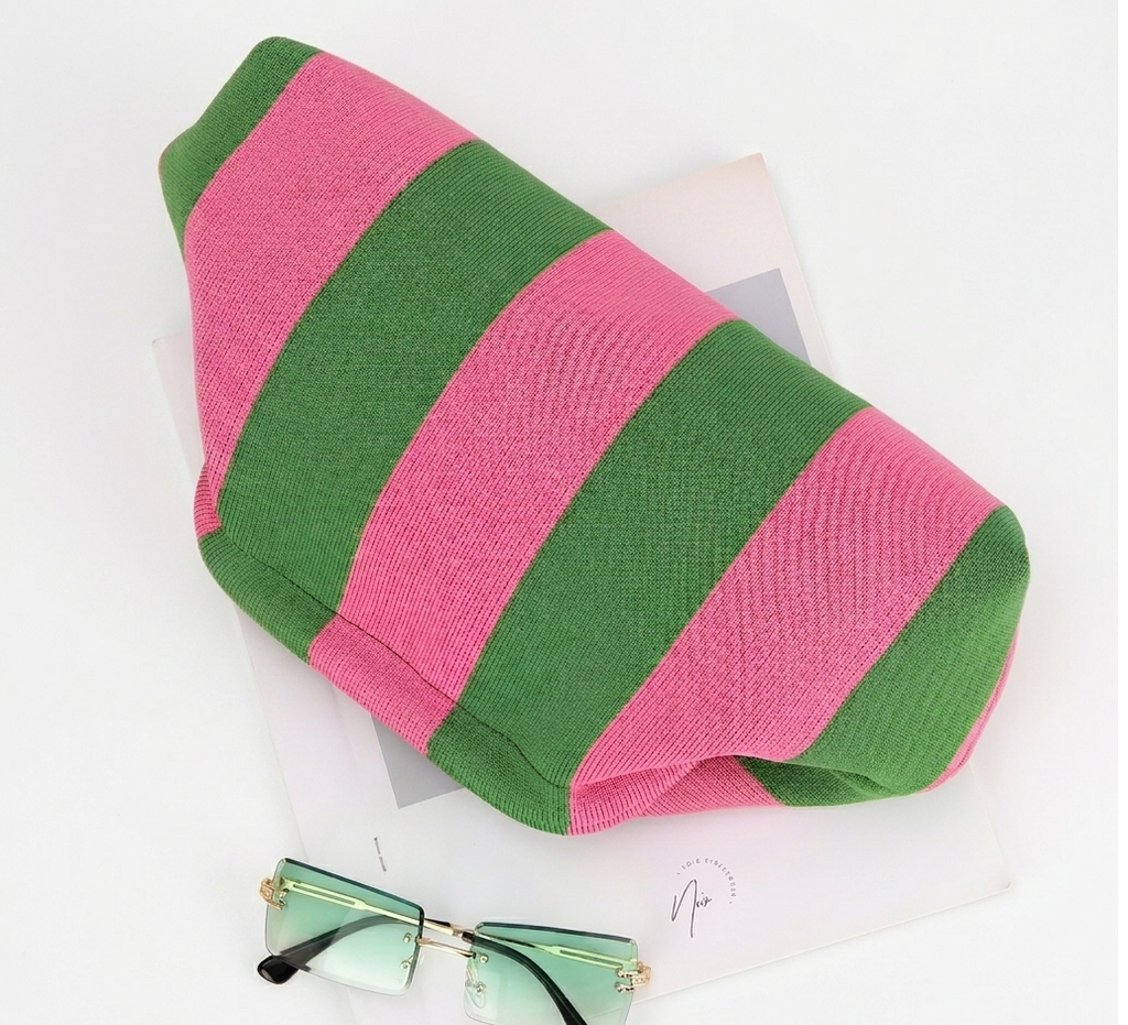 Pink and green striped sock with a pair of sunglasses on a white background