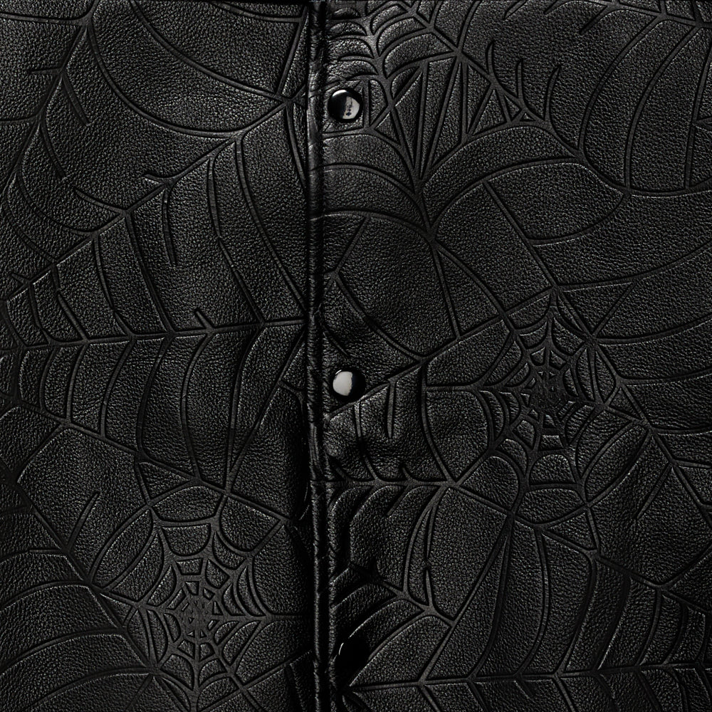 Detail view of studded text on SP5DER Debossed Web Leather Jacket in Black