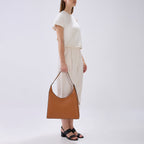 Bag It Danny Flatiron clay pebble leather shoulder bag carried by hand