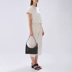 Bag It Danny Flatiron black leather shoulder bag carried by hand