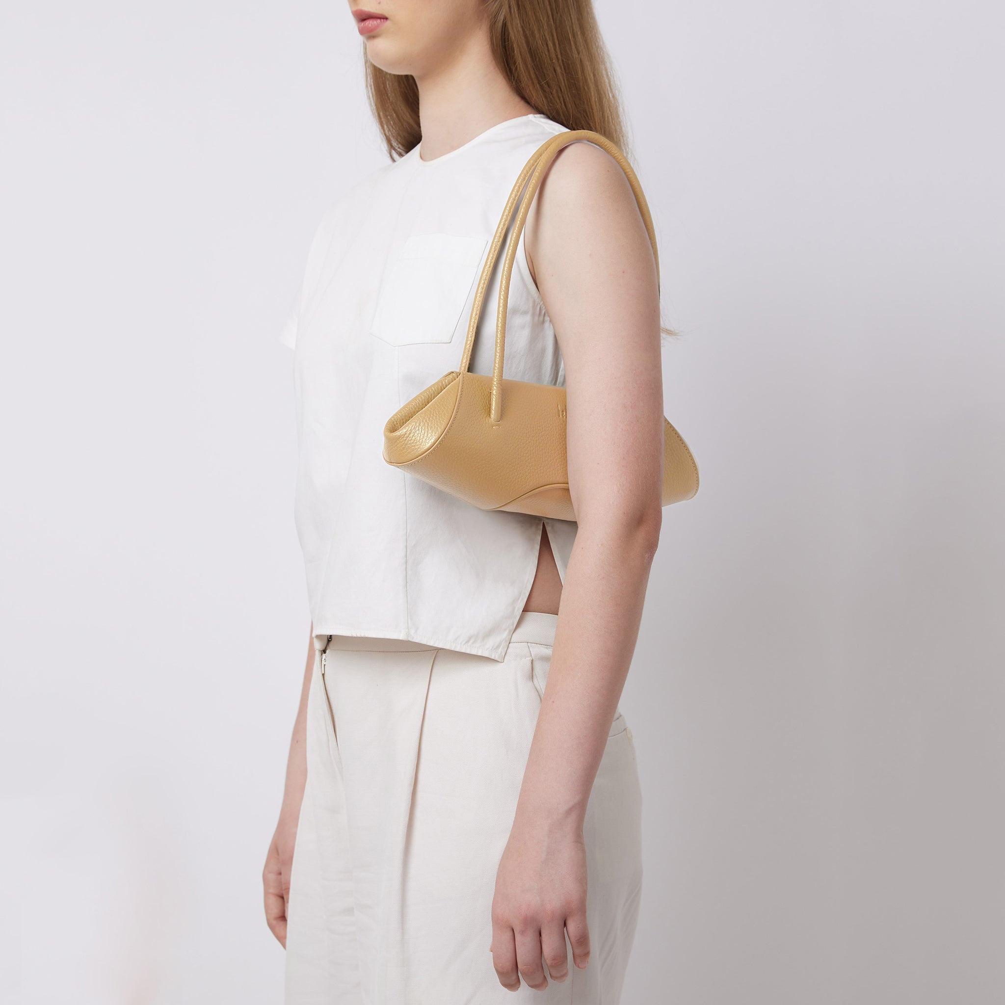 Bag It Elizabeth mini bisque baguette bag worn on the shoulder