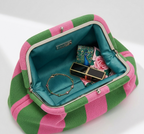 Open green and pink striped handbag with jewelry and makeup items on a white background