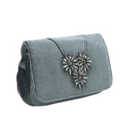 Blue clutch bag with a decorative heart brooch on a white background