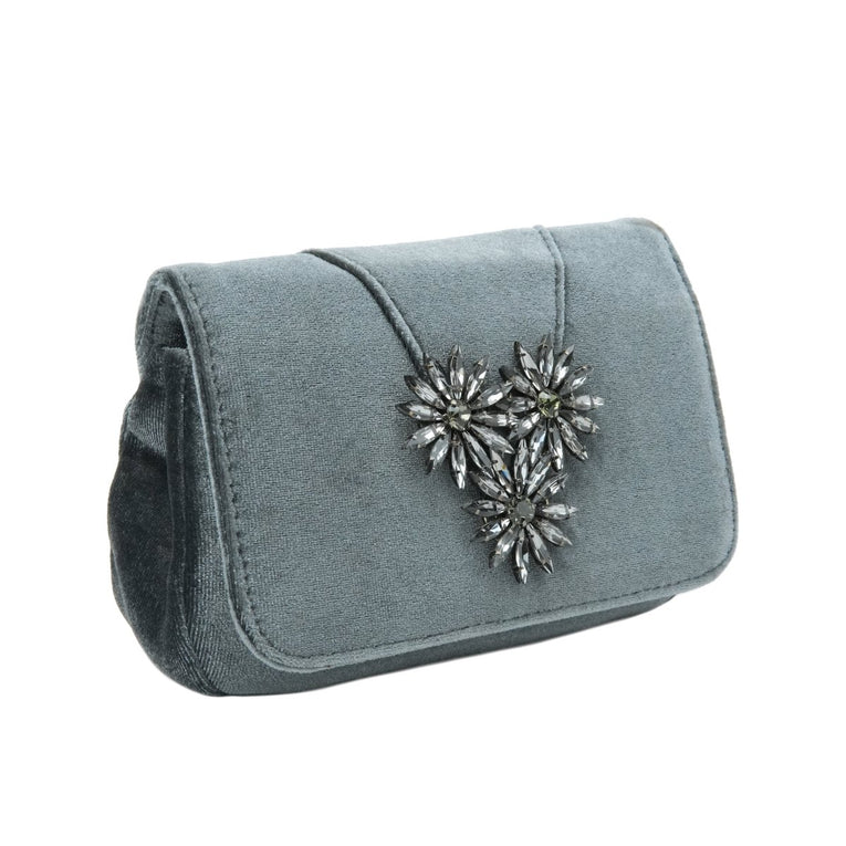 Blue clutch bag with a decorative heart brooch on a white background