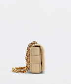 Beige handbag with gold chain on a light gray background