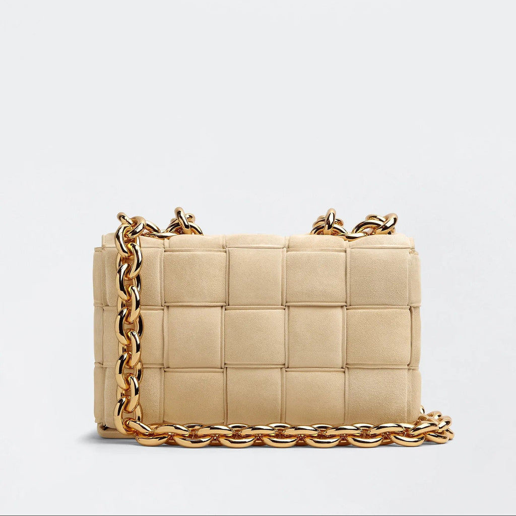 Beige handbag with gold chain on a light gray background