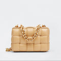 Beige handbag with a gold chain on a light gray background