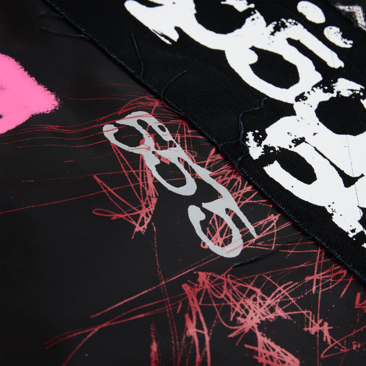 Detail view of embroidered sleeve text on SP5DER Vet Bomber Jacket in Black