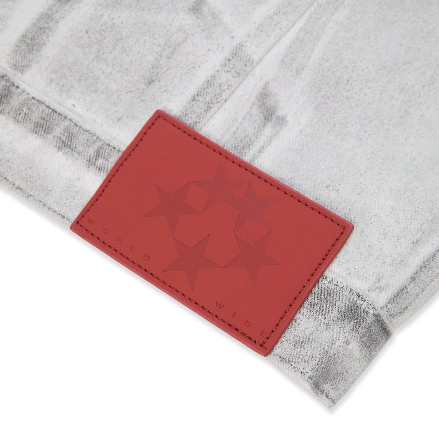 Detail view of adjustable hem tabs on SP5DER Platinum Trucker Jacket in Grey