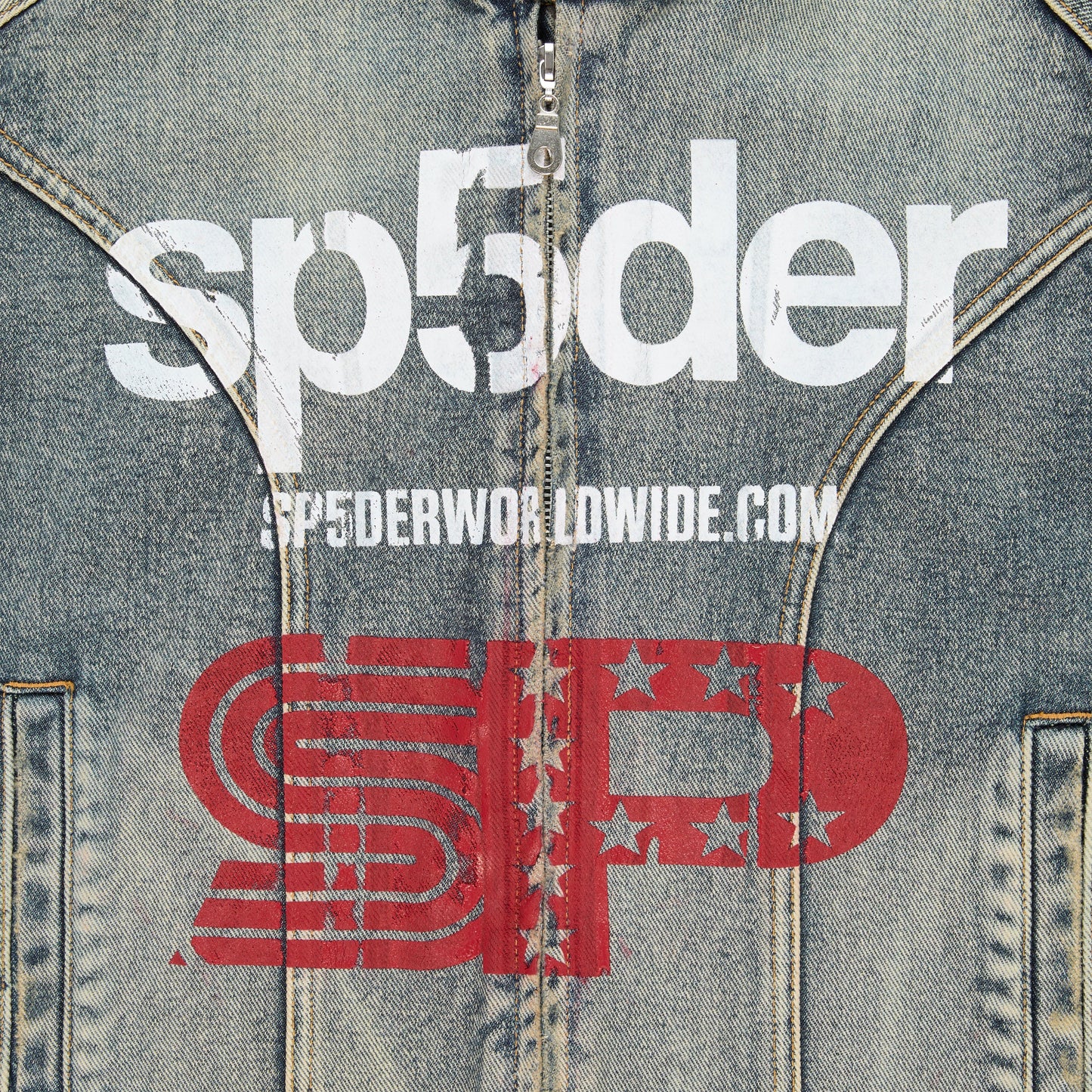 Detail view of SP5DER print on chest of Motorsport Denim Jacket in Indigo