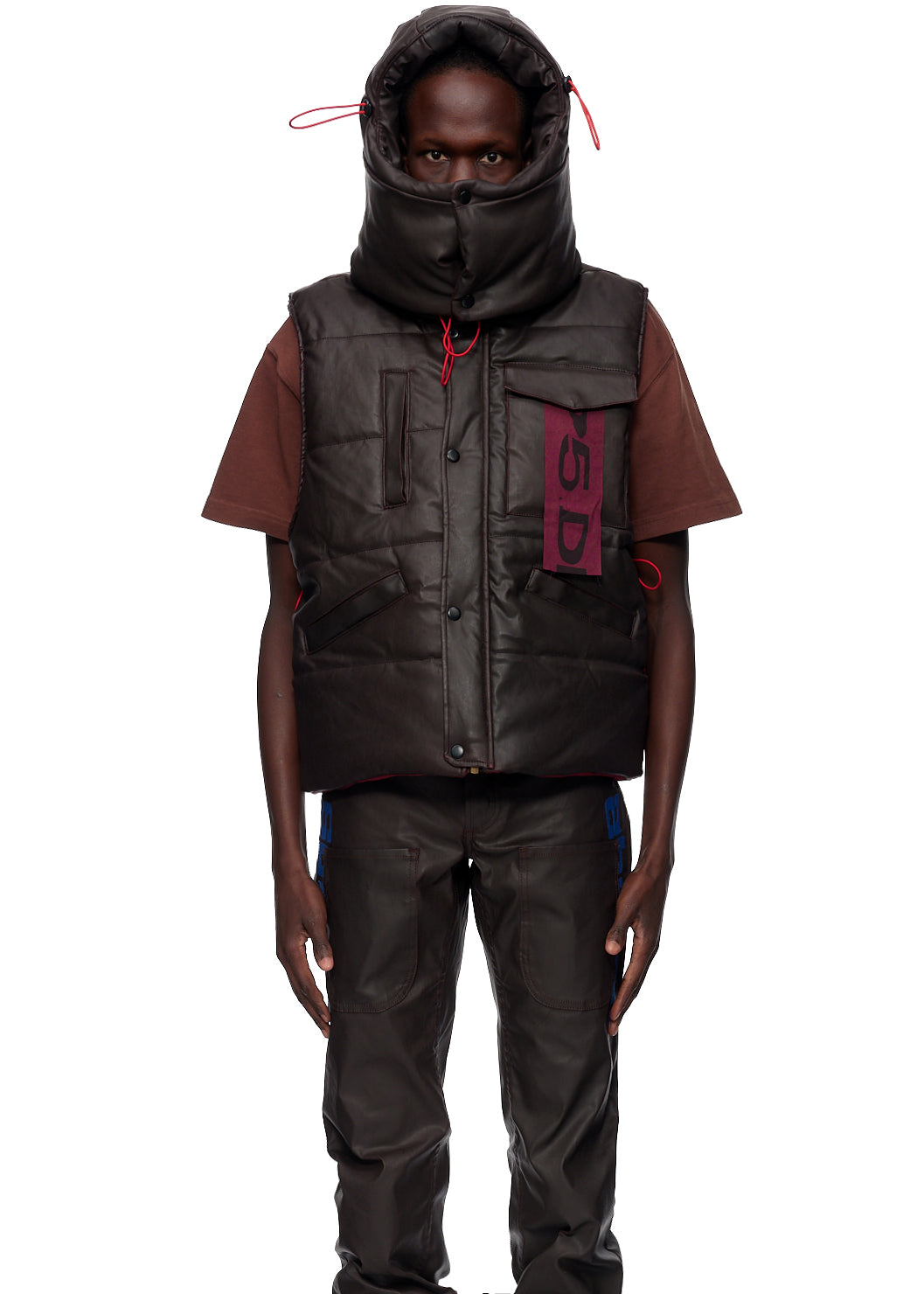 Detail view of SP5DER branded label on Hooded Puffer Vest in Brown