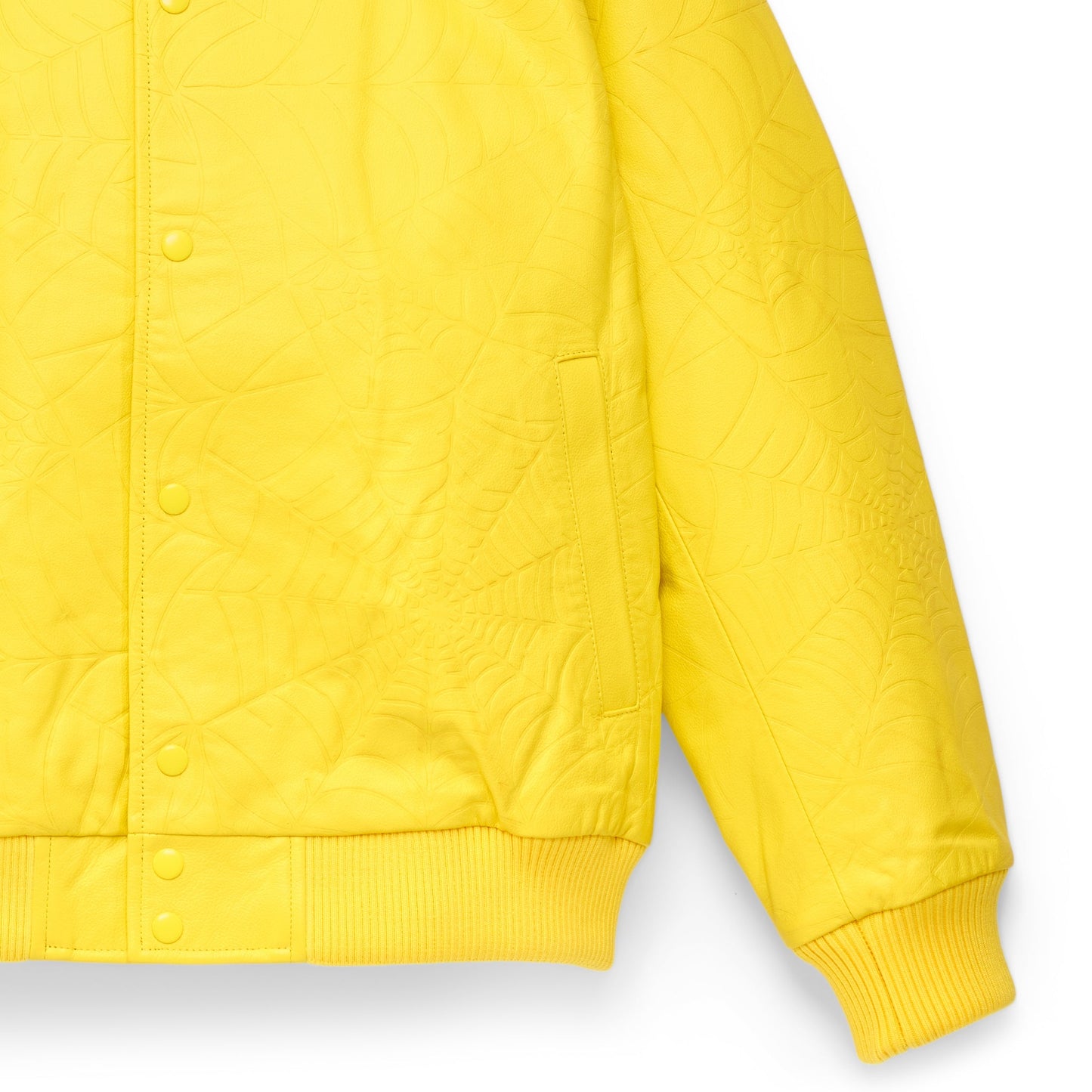 Detail view of studded text on SP5DER Debossed Web Leather Jacket in Yellow