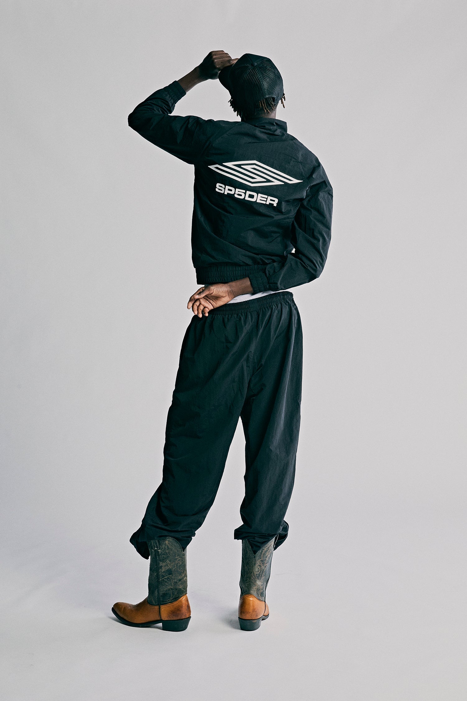 Model wearing SP5DER Pro Windbreaker in Black additional angle