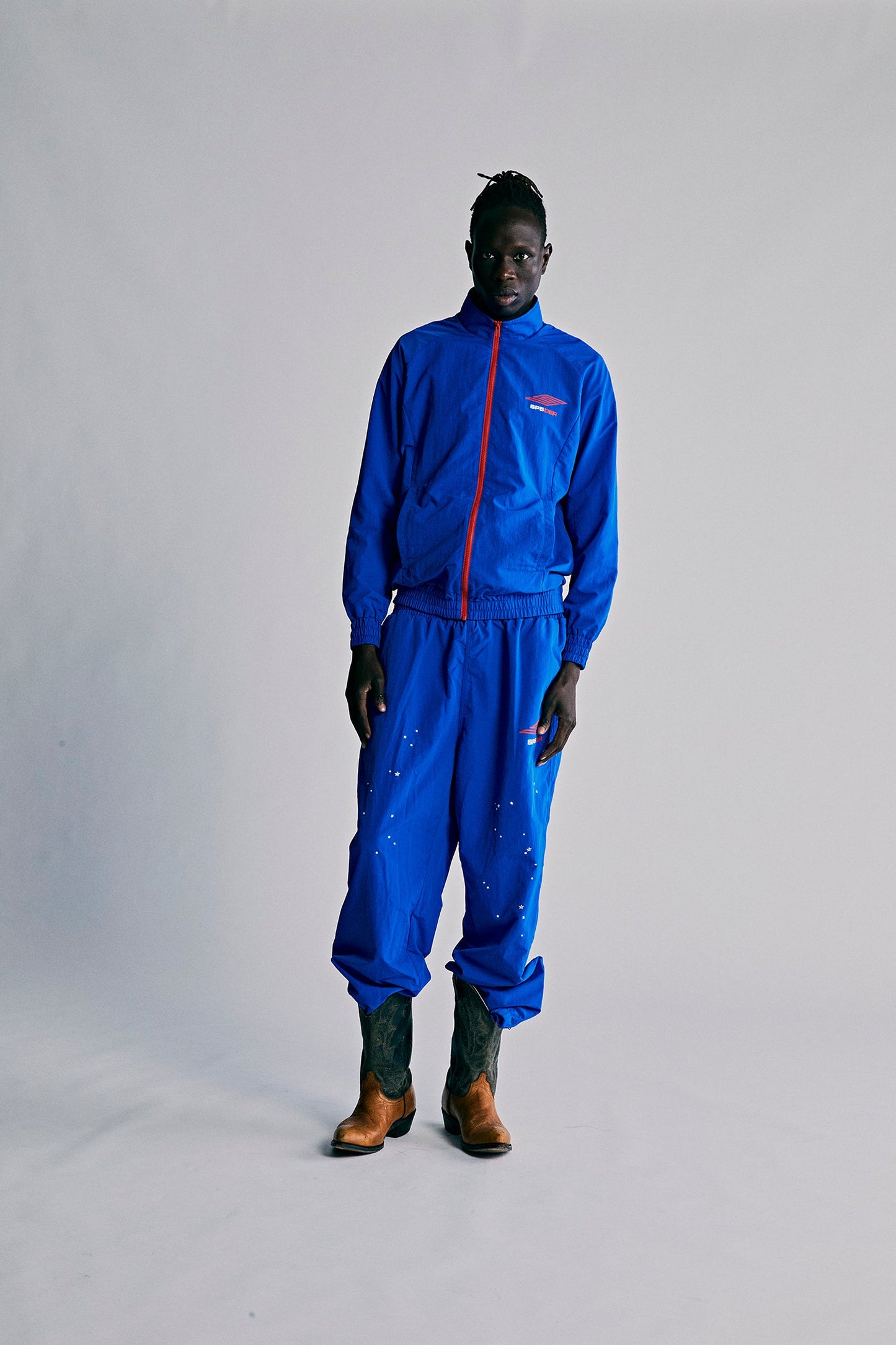 Model wearing SP5DER Pro Windbreaker in Blue side view