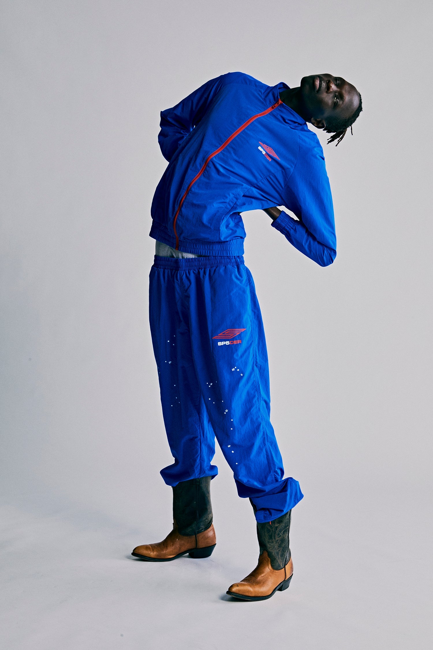 Model wearing SP5DER Pro Windbreaker in Blue back view