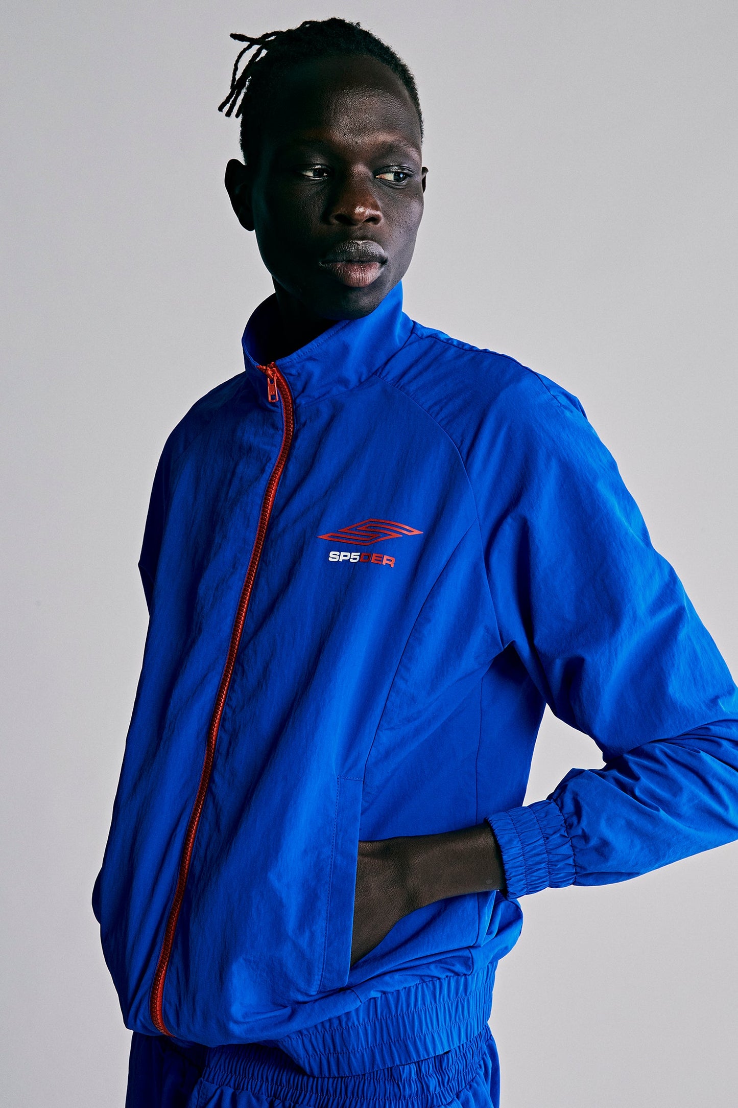 Model wearing SP5DER Pro Windbreaker in Blue front view