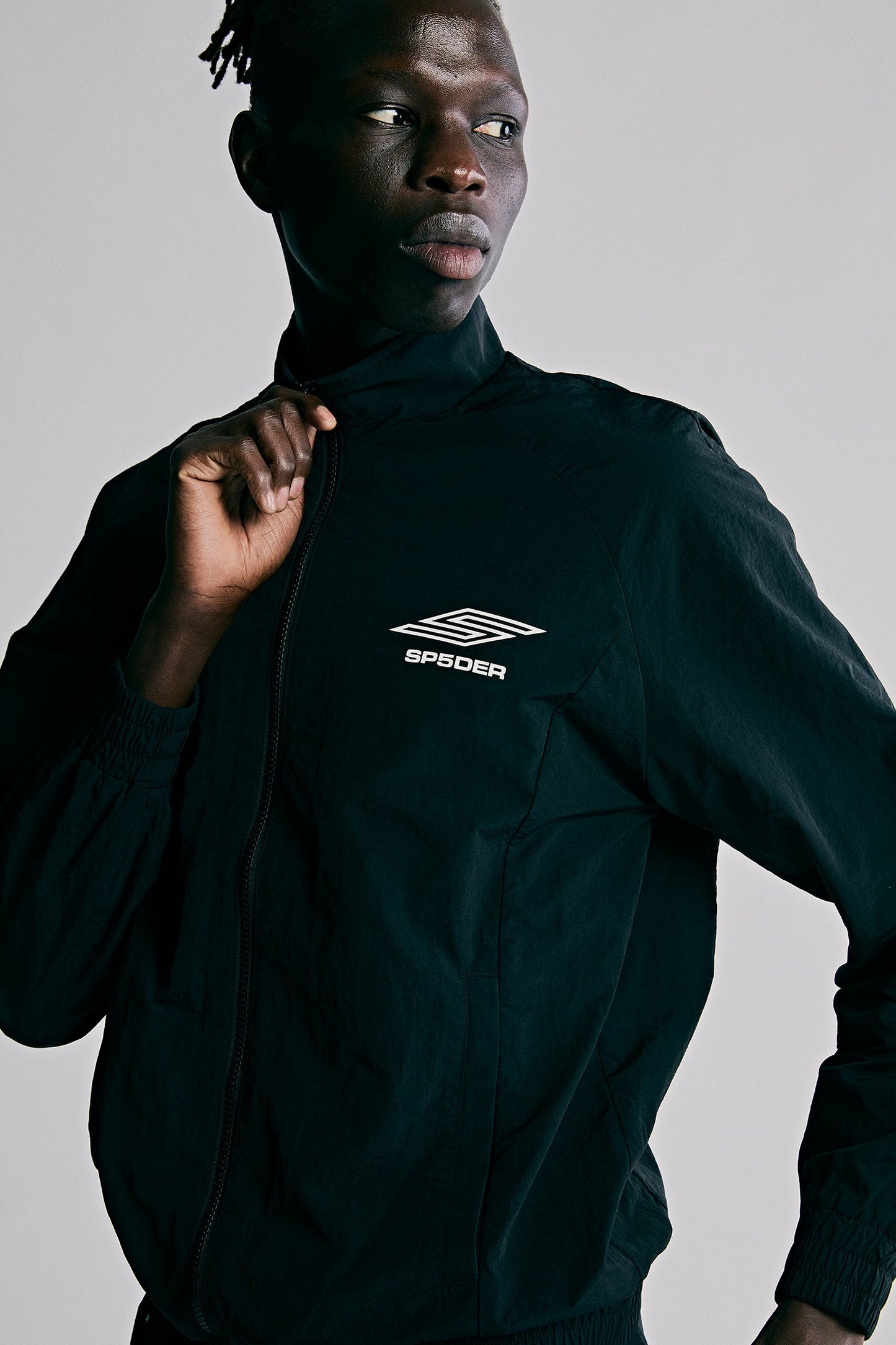 Model wearing SP5DER Pro Windbreaker in Black front view